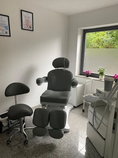 Heller Behandlungsraum mit Fenster und Blumen